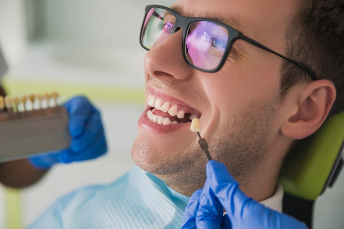 Dentist showing patient single dental implant supported crown